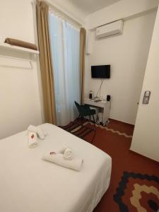 a hotel room with a bed and a desk with a television at Le Camere di Suleima in Messina