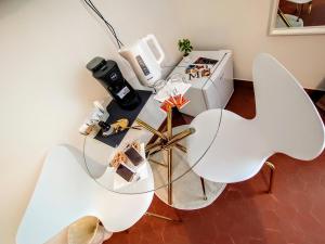 two white chairs and a table in a room at Le Camere di Suleima in Messina