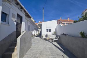 an alley with white buildings and a table and chairs at Cascais Garden House 103 in Cascais