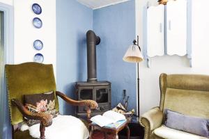 a living room with a wood stove and a chair at 13301-1-Asnaes-Lindevej-5 in Asnæs