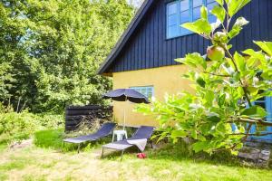 two chairs and an umbrella in front of a house at 13301-1-Asnaes-Lindevej-5 in Asnæs