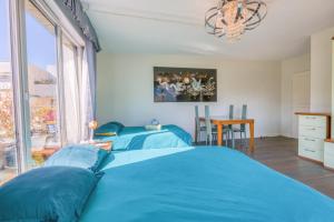 a bedroom with two blue beds and a table at Private Room in Coliving - Paris 10min - by Cosynousvoici in Asnières-sur-Seine