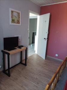 a room with a desk with a computer and a door at L'annexe in Chalindrey