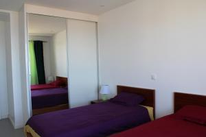 a bedroom with two beds and a mirror at Casa Thisolore in Ponta do Sol