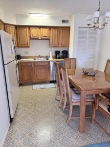a kitchen with a wooden table and a refrigerator at Vermont By The Sea in Cape May