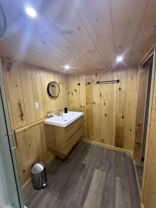 a bathroom with a white sink in a wooden wall at Espace des Grands-Ducs - Domaine de Lacs et de forêt in Sacré-Coeur-Saguenay +138 photos