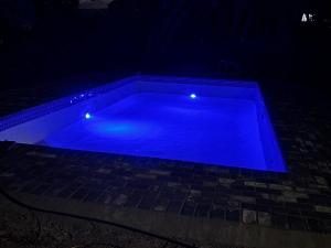 a blue swimming pool at night with lights at Spring Day in Piet Retief