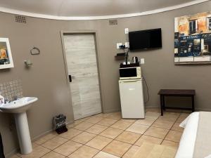 a bathroom with a sink and a door with a microwave at Spring Day in Piet Retief