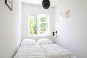 a bed in a white room with a window at 14235-Grevinge-Askebjerggardsvej-20 in Grevinge