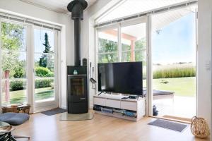 a living room with a flat screen tv and large windows at 14235-Grevinge-Askebjerggardsvej-20 in Grevinge