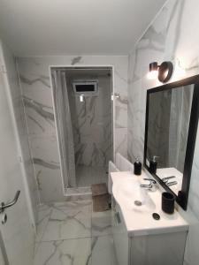 a white bathroom with a sink and a shower at Sons da Ribeira in Ribeira Grande