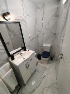 a white bathroom with a sink and a toilet at Sons da Ribeira in Ribeira Grande