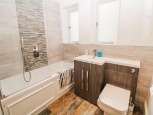 a bathroom with a tub and a toilet and a sink at Gulliver's in Matlock