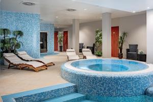 a pool in a lobby with lounge chairs and a spa at VILNIUS PARK PLAZA HOTEL & SPA, Restaurant, Conference & Banquet Center in Vilnius