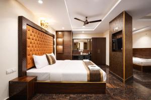 a hotel room with a bed and a television at Hotel Well Suites Koramangala in Bangalore