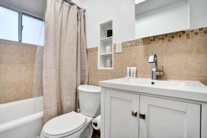 a white bathroom with a toilet and a sink at Lucerne Collection Private 4-Unit Building in Lake Worth
