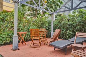 a patio with chairs and a table and an umbrella at Lucerne Collection Private 4-Unit Building in Lake Worth +64 photos