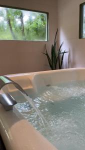 a bath tub with water coming out of it at Pousada ROCA in Ibiúna +37 photos