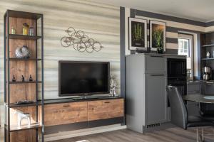 a living room with a television and a table at Apartment Deichblick in Büsum