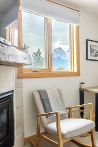 a chair sitting in front of a window with a view at Morningside - Pet Friendly Stunning Mtn Views in Canmore