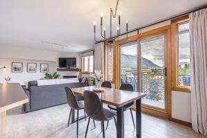 a dining room and living room with a table and chairs at Morningside - Pet Friendly Stunning Mtn Views in Canmore