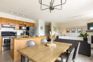 a kitchen and living room with a wooden table at Morningside - Pet Friendly Stunning Mtn Views in Canmore
