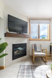 a living room with a fireplace with a flat screen tv at Morningside - Pet Friendly Stunning Mtn Views in Canmore +41 photos