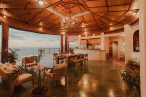 a living room with a table and chairs and the ocean at Private Cliffside Villa with Infinity Pool in Sayulita