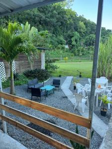 a patio with chairs and tables in a yard at Domaine de Locastel 2 in Morne-à-lʼEau