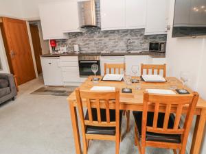 a kitchen with a wooden table with chairs and wine glasses at Abraham in Matlock