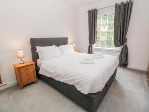 a bedroom with a bed with white sheets and a window at Abraham in Matlock