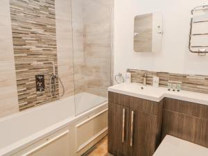 a bathroom with a shower and a sink and a tub at Abraham in Matlock +12 photos