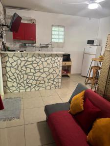 a living room with a couch and a kitchen at Domaine de Locastel 2 in Morne-à-lʼEau