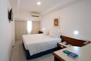 a hotel room with a bed and a desk at Hotel Bandeirantes in Rio de Janeiro +40 photos