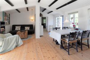 a dining room and living room with a table and chairs at 16664-Farevejle-Klinteborgvej-7 in Fårevejle +15 photos