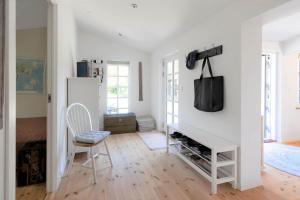 a white room with a chair and a tv on a wall at 16664-Farevejle-Klinteborgvej-7 in Fårevejle