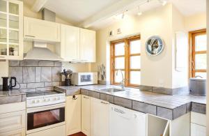 a kitchen with white cabinets and a sink at 12228-Sjaellands-Odde-Strandvaenget-23 in Yderby