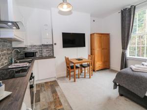 a kitchen and living room with a table and a bed at Masson in Matlock