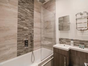 a bathroom with a tub and a sink and a shower at Masson in Matlock