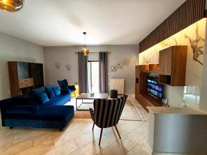 a living room with a blue couch and a table at Meteora House with a view in Kalabaka