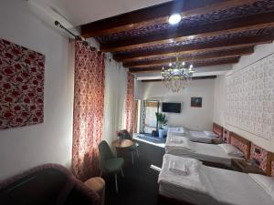 a hotel room with beds and a chandelier at Dolon B&B Hotel in Bukhara