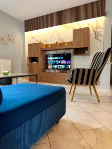 a room with a bed and a chair and a television at Meteora House with a view in Kalabaka