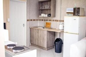 a kitchen with a sink and a refrigerator at Revitalize in Springs +1 photo