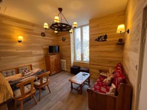 a living room with wooden walls and a dining room at Les Roitelets "MONTAGNARD" - Appartement T2 avec Mezzanine - Thème Montagne - Entièrement NEUF - Classé 3 étoiles - Proche Centre-ville & Thermes - Ménage et Linge de maison INCLUS in La Bourboule