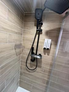 a shower with a shower head in a bathroom at Les Roitelets "MONTAGNARD" - Appartement T2 avec Mezzanine - Thème Montagne - Entièrement NEUF - Classé 3 étoiles - Proche Centre-ville & Thermes - Ménage et Linge de maison INCLUS in La Bourboule +20 photos