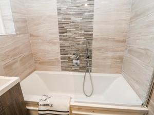 a white bath tub with a shower in a bathroom at High Tor in Matlock +8 photos
