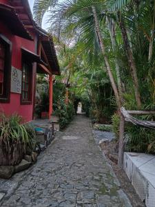 a cobblestone path next to a house with palm trees at Okakoaras Hotel in Paulista +18 photos