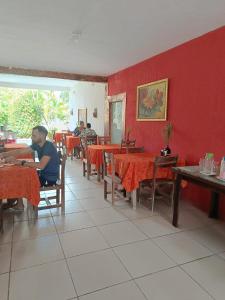 a man sitting at a table in a restaurant at Okakoaras Hotel in Paulista