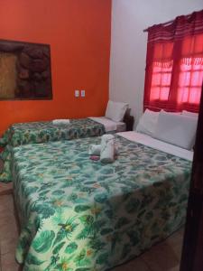 two beds in a room with a stuffed animal on the bed at Okakoaras Hotel in Paulista