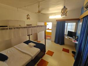 a bedroom with a bed and a desk with a computer at Serene Waters Homestay Goa in Panaji +68 photos